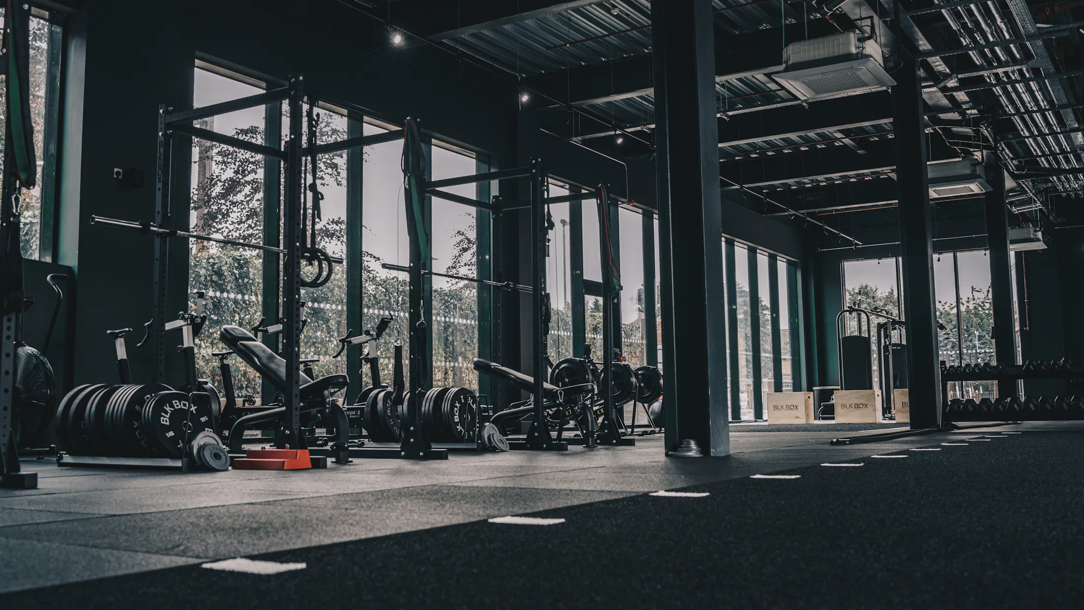 Squat racks and loaded barbells on the strength floor at Xavion Fitness Studio, Thindal
